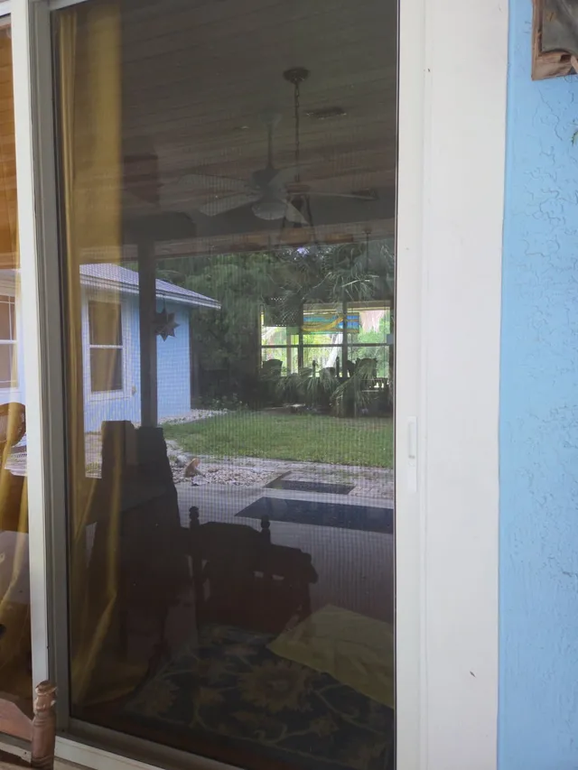 Glass patio door and threshold beside a light blue exterior wall