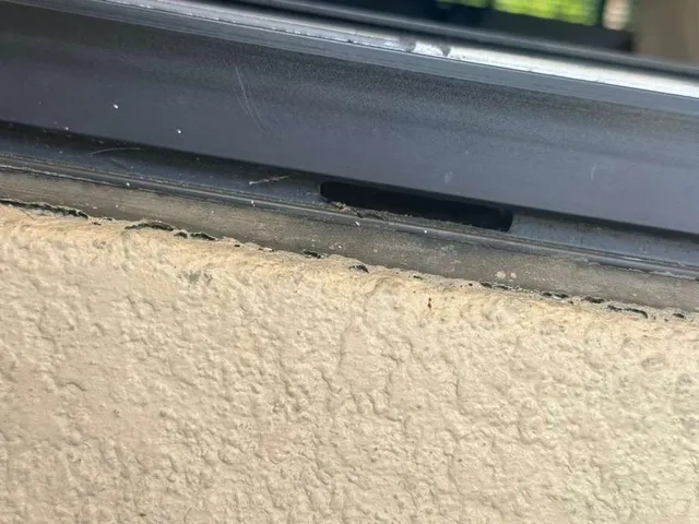 Close view of the lower sliding door frame above a concrete sill