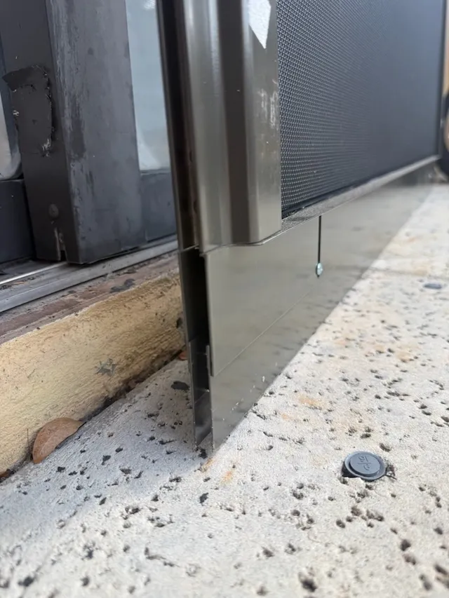 Lower corner of a sliding door panel beside the track