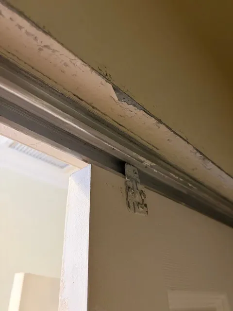 Upper sliding door track and surrounding trim viewed from below