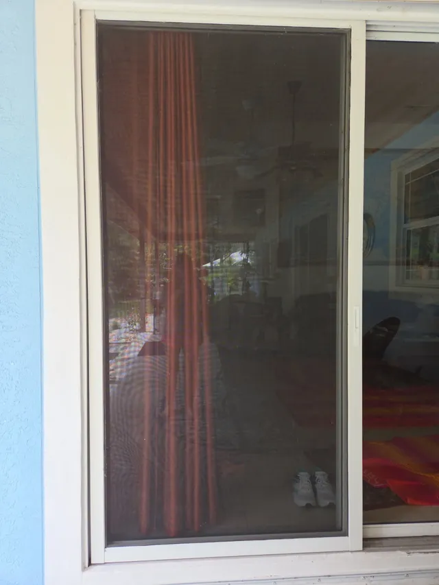 White sliding door frame and glass panel viewed from the patio